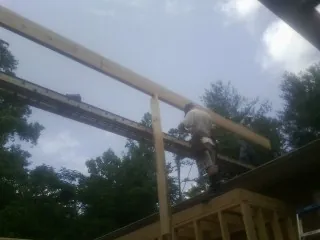Carpenter setting a ridge beam over a new addition frame — Ice Dam Removal by Roofing Brothers in Oak Harbor